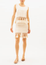 The model is wearing a ecru mini skirt with tassels at the hemline