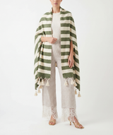 Woman wearing a green and white striped shawl with tassels on a white background