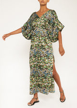 The model is wearing a green leopard print caftan dress features a V neckline, half kimono sleeves, and side slits.