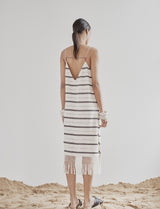 A model wearing a cotton handloomed black and ecru sleeveless dress with beadings on the back