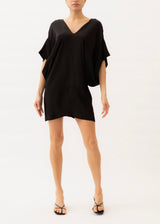 Model is wearing a black short dress with kimono sleeves