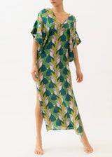The model is wearing a long caftan in a green leaf pattern design