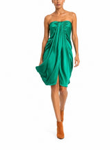 Woman wearing a green strapless dress on a white background