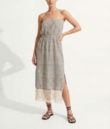 Woman wearing a strapless striped dress with handwoven fringes on a white background