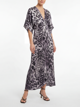 Woman wearing a leopard print maxi dress on a white background
