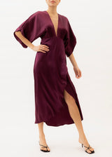 The model is wearing a Burgundy silk maxi dress