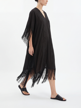 Black fringe dress worn by a model on a white background