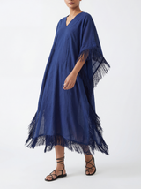 Woman wearing a navy blue caftan with silk navy fringes on a white background