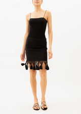 A Model wearing a black short cotton handloomed skirt with tassels