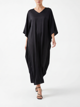 Person wearing a black dress with a cape on a white background