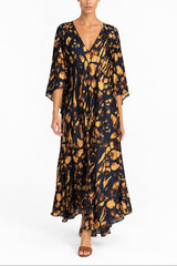 Woman wearing a long maxi v neck scarf cut 3/4 sleeve kaftan in a navy blue and gold abstract print 