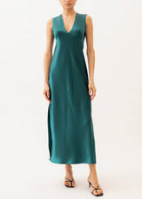 Model is wearing a teal silk maxi gown with v-neckline