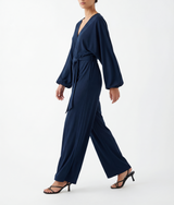 A woman wearing a Navy blue jumpsuit on a white background