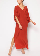 The model is wearing a Rust silk caftan with a kimono sleeve