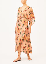 The model is wearing a light pink floral maxi dress