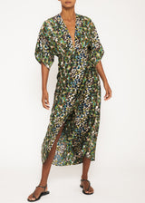 The model is wearing a  green leopard print dress with a An empire waistline, plunging neckline, half kimono sleeves, hook eye closure, and wrap-style skirt 