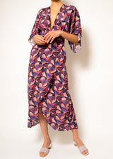 The model is wearing a Pink geo wrap maxi dress