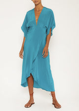 The model is wearing a turquoise dress, featuring an empire waistline, plunging neckline, half kimono sleeves, concealed hook eye closure, and wrap-style skirt,