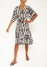 The model is wearing a midi print black and white dress with glowers prints