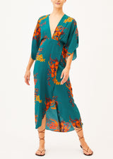 The model is wearing a backless green floral maxi dress