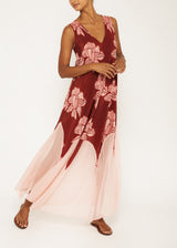 The model is wearing a caftan crafted using a mixture of silk and chiffon and decorated with an elegant floral pattern and subtle pink panels. It has a v-neckline, a flattering skirt with cutout chiffon details