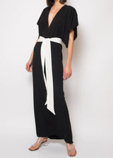 The model is wearing a Black silk V neck dress with white tie