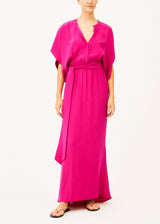 The model is wearing a maxi pink dress