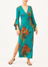 The model is wearing a green patterned silk maxi dress